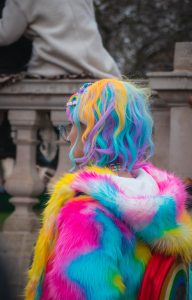 selective color photography of woman wearing blue, yellow, and pink coat and hair