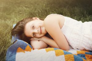 girl lies on textile on grass