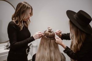 a woman getting her hair styled by another woman
